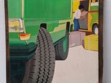 une image représentant un camion vert sur lequel est posé un pneu