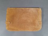 a close up of a brown purse on a gray surface