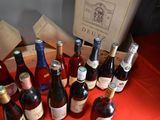 many bottles of wine sitting on a table with a red table cloth