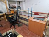 a desk and a chair in a room with a lot of clutter
