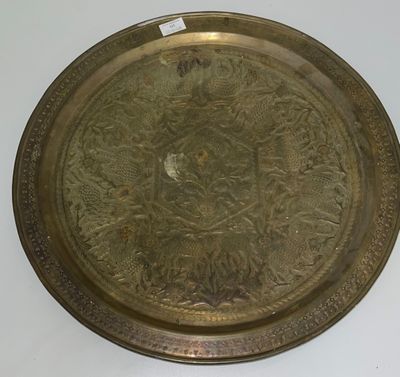 an antique brass tray with a floral design on it