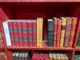 de nombreux livres sur une étagère rouge dans une bibliothèque