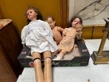 three dolls that are sitting in a box on a table