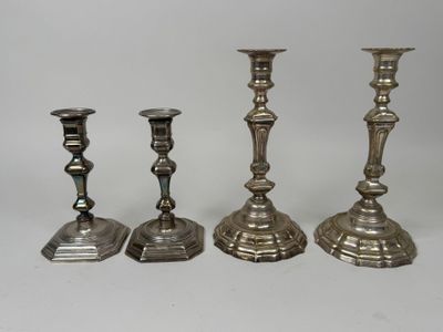 trois bougeoirs en argent posés les uns à côté des autres sur une table