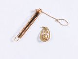 a gold necklace and a pair of scissors on a white surface