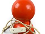 a red toy with a rope around it on a white surface
