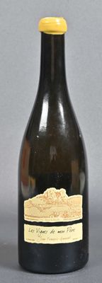 a black bottle with a yellow top on a gray surface