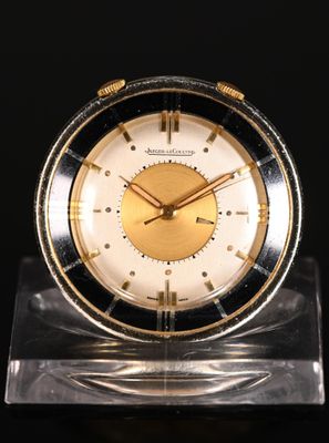 an image of a gold and black clock sitting on top of a clear base