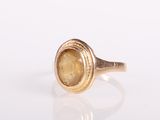 a close up of a gold ring with a yellow stone in it