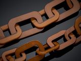 two brown chains on a black surface with a black background