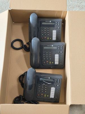 deux téléphones noirs dans une boîte en carton posée par terre