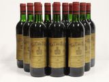 six bottles of wine are lined up in a row on a table