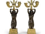 une paire de bougeoirs en bronze représentant des personnages tenant un candélabre