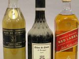 trois bouteilles d'alcool placées les unes à côté des autres sur une table