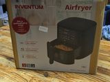 an open box of an air fryer sitting on a wooden table