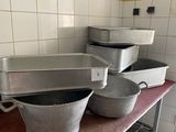 Plusieurs casseroles sont alignées sur une table dans une cuisine
