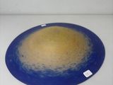 a blue plate with a yellow center on a white surface