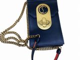 the small blue purse has a chain around it and a gold clasp