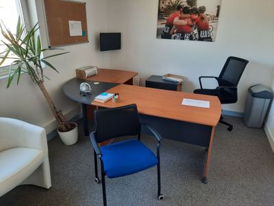 un bureau et une chaise dans une pièce où il y a un tableau accroché au mur