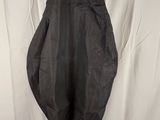 a black dress hanging on a hanger against a white backdrop