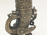 un vase en argent orné d'un dragon sur fond blanc
