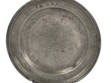 une assiette en argent ornée d'une image sur fond blanc
