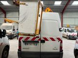 vehicles are parked in a large warehouse with a crane in the back
