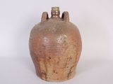 a brown vase that is sitting on a white surface