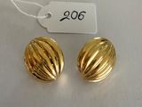 a pair of gold earrings with a price tag on a white table