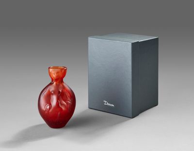 a red vase sitting next to a box on a table