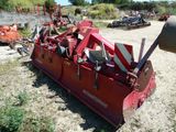 une grosse machine rouge qui est garée dans la poussière