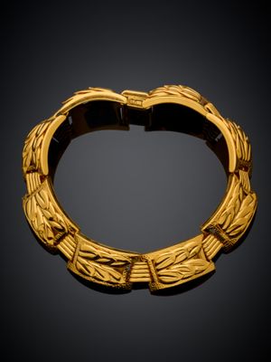 une image représentant un bracelet en or sur fond noir
