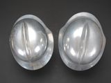pair of silver hard hats sitting on top of a black surface