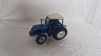 a toy tractor that is sitting on a white surface