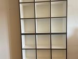 a tall bookcase with many shelves in the room