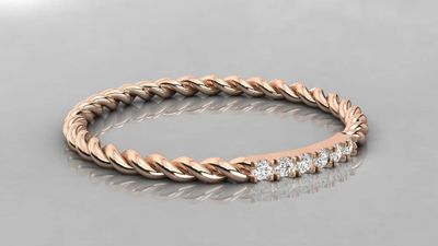 a rose gold ring with diamonds on a reflective surface