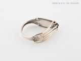 a close up of a silver ring on a white surface