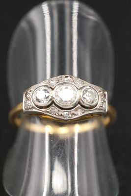 gros plan d'une bague en or ornée de trois diamants