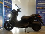 a black motorcycle parked in a showroom next to a blue wall