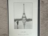 a black and white photo of a person standing in front of the eiffel tower