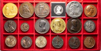 an assortment of coins in a red box on a white background