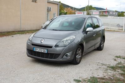 une voiture grise garée dans un parking à côté d'un bâtiment