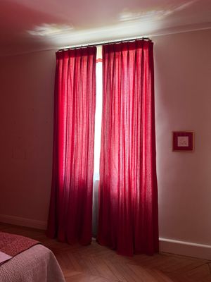 une chambre avec un lit et des rideaux rouges