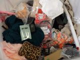 a white trash can filled with clothes and other items