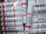 plusieurs tubes de colle dans une boîte en carton posée sur une table