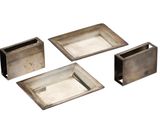 four pieces of silver metal are arranged on a white surface