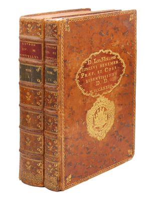 un vieux livre à la couverture dorée posé sur une surface blanche
