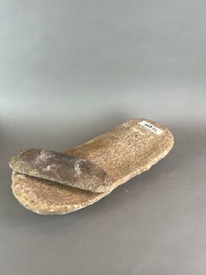 une miche de pain posée sur une table à côté d'une bouteille de bière