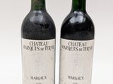 deux bouteilles de vin rouge posées l'une à côté de l'autre sur une surface blanche