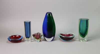 cinq vases en verre de couleurs différentes, disposés les uns à côté des autres